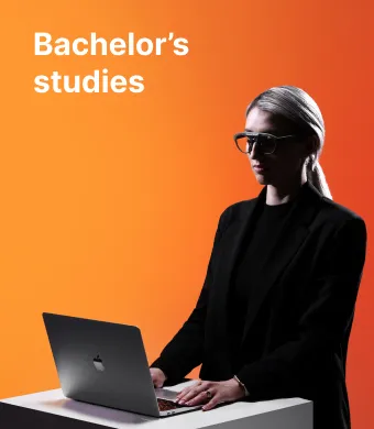 A KTU School of Economics and Business student working on a laptop against an orange decorative background. The faculty offers bachelor's studies. Choose KTU bachelor's studies.